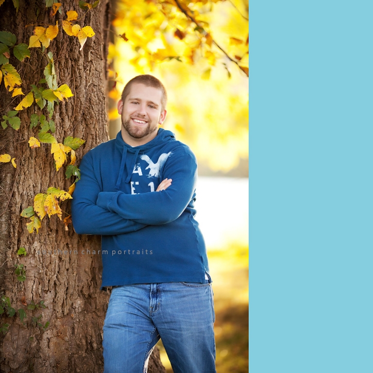 senior guy fall day at park leaning against tree yellow golden sunlight