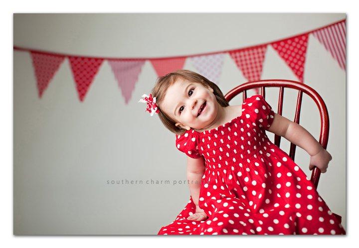 child smiling and leaning out of chair in portrait studio in lafollette tn