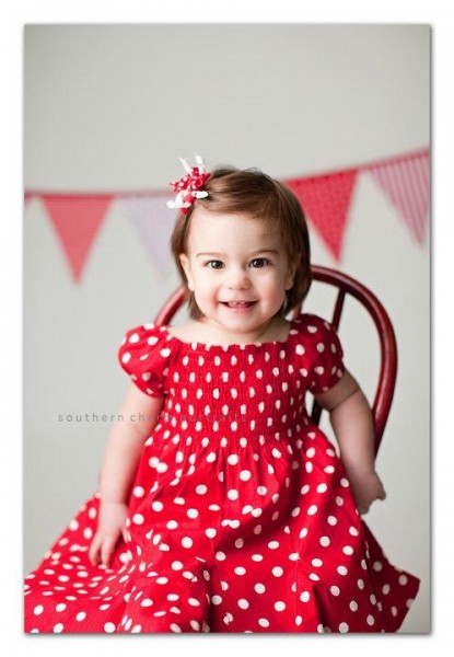 one year old with little teeth peaking through when she smiles
