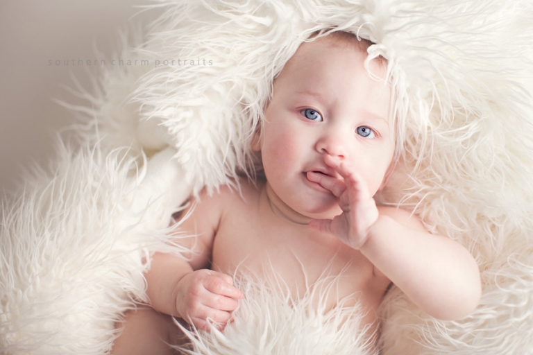 9 month old baby laying in crate in portrait studio