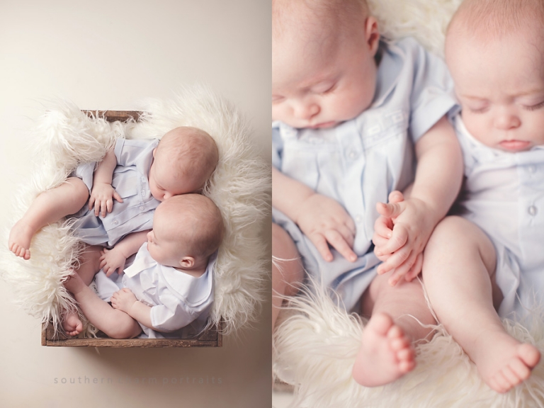 baby boys sleep together and hold hands in wooden crate