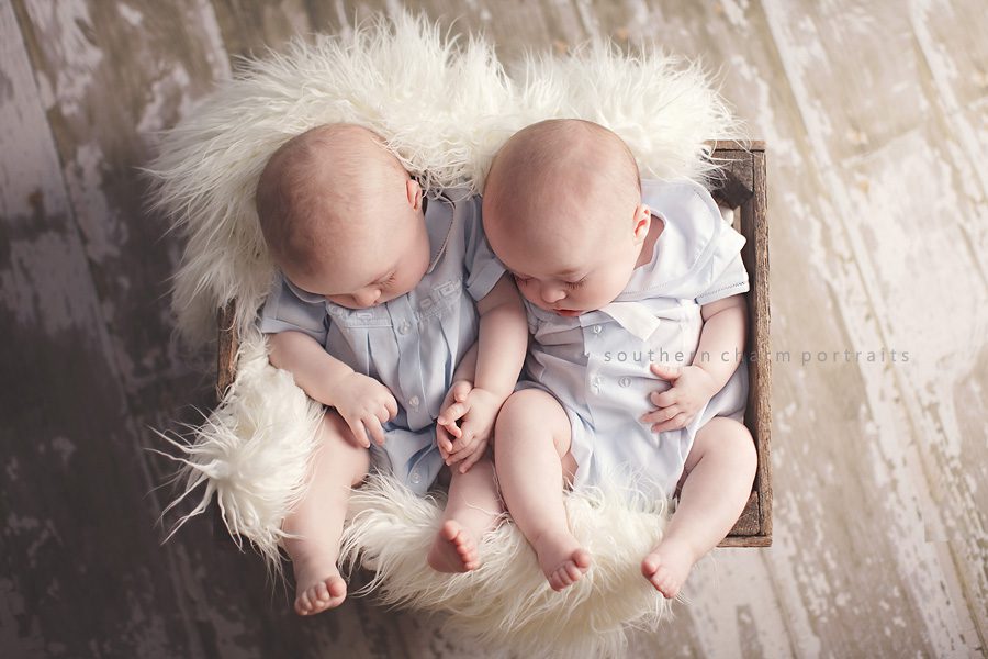 baby boys in wooden crate sleeping on barn floor