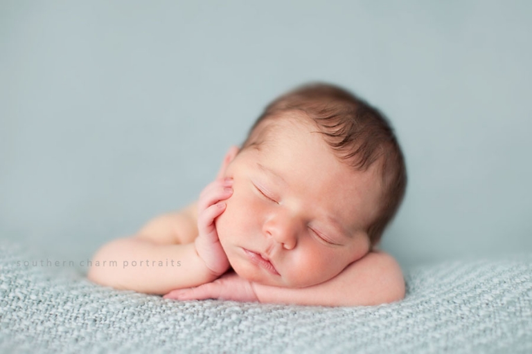 baby sleeping propped up with hand