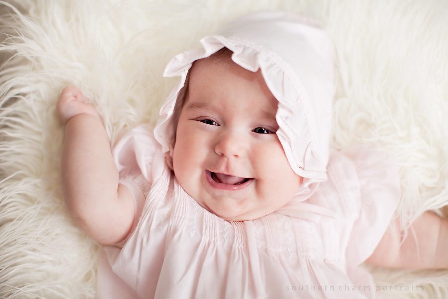 baby girl in pink dress with bonnet