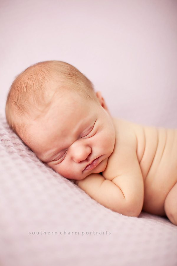 baby sleeping on pink blanket in portrait studio